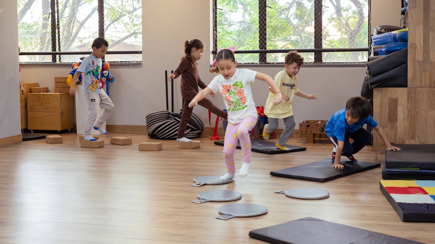 Niños y niñas juegan saltando en un salón de Cosmo.