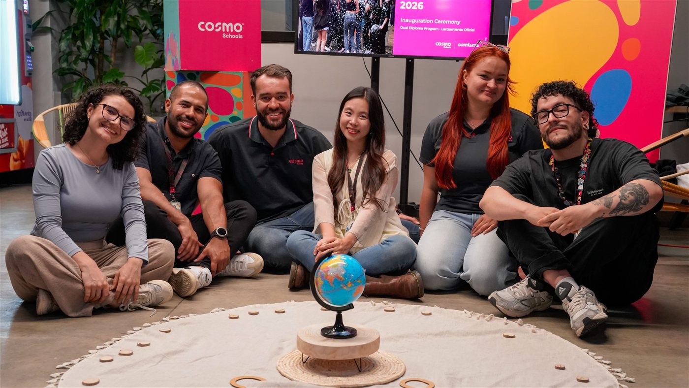 Equipo del programa Dual Diploma sentado alrededor de un globo terráqueo en la ceremonia de lanzamiento