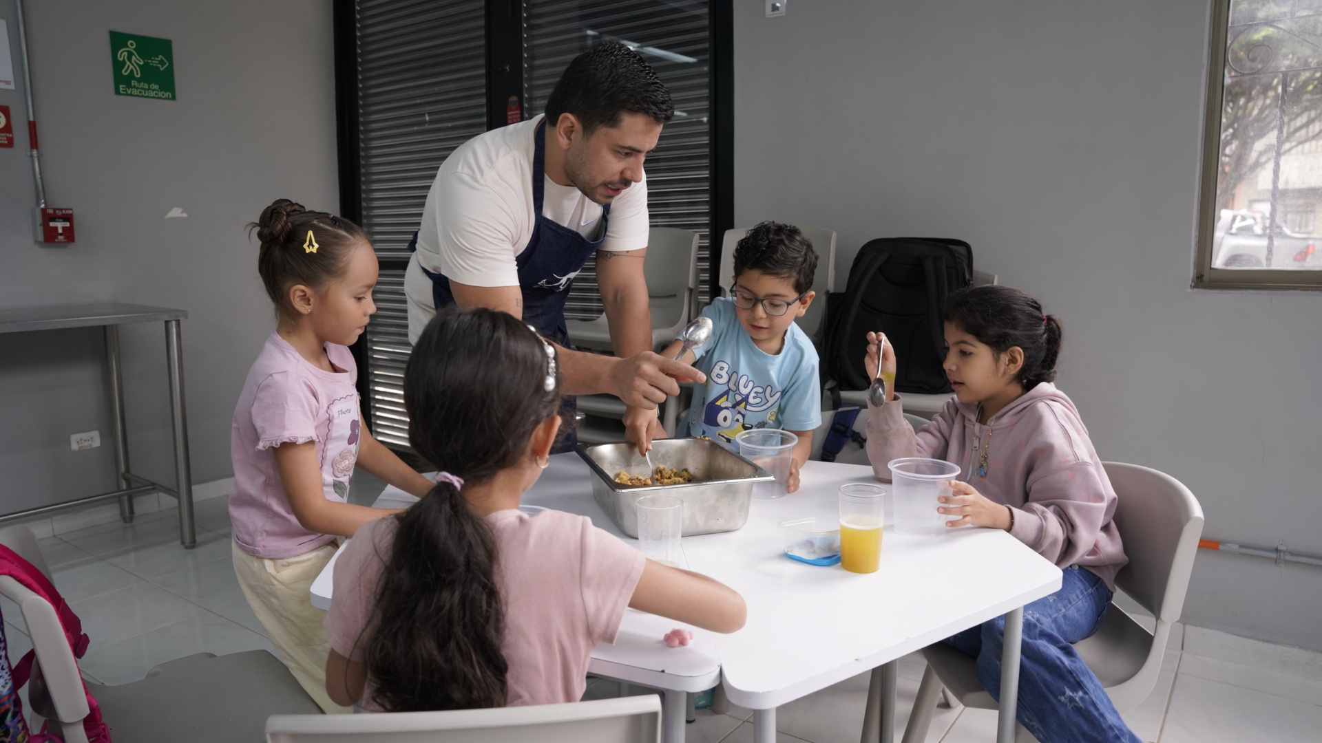 Niños cocinando en el Summer Camp junto a un chef
