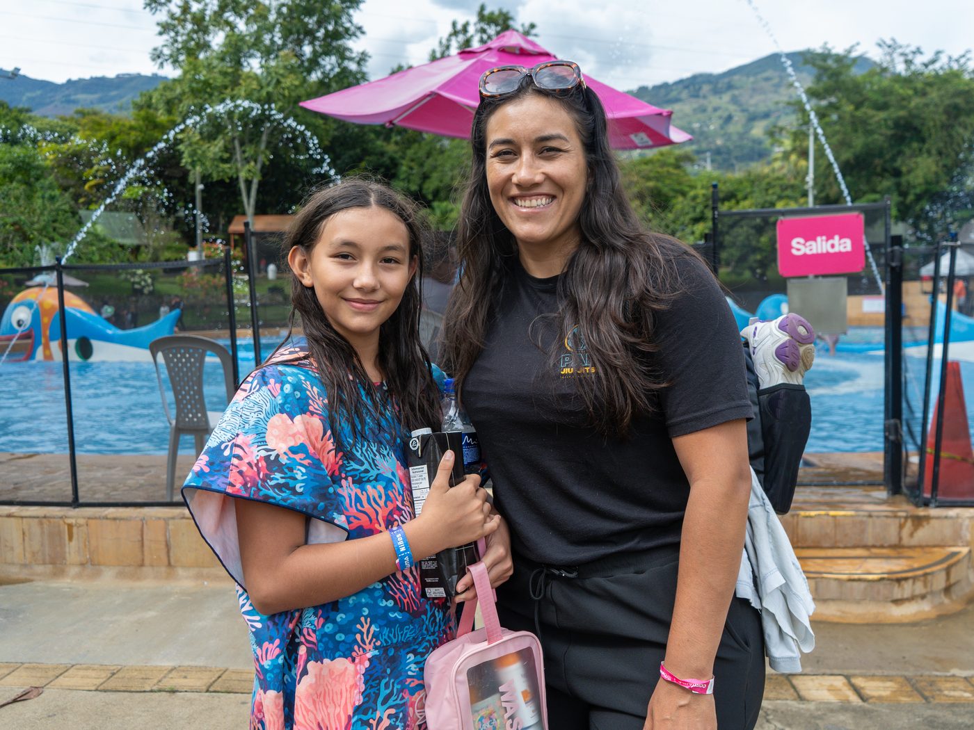 Una mamá y su hija junto a las piscinas del Parque Comfama